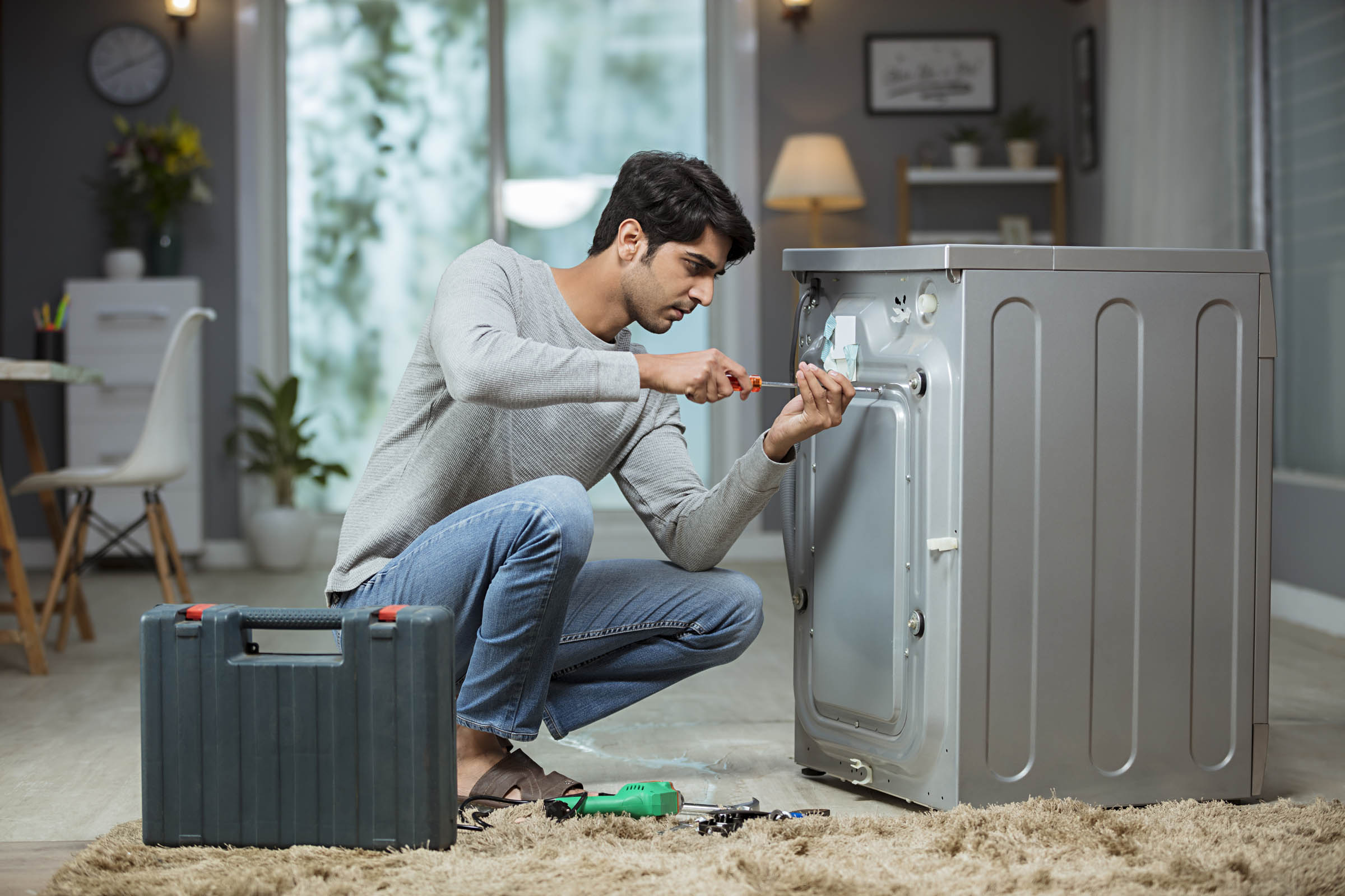 Professional appliance repair technician working on home equipment
