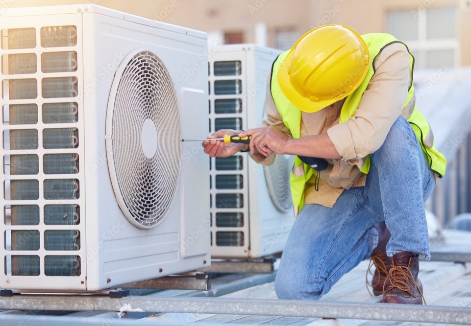 Professional AC repair technician working on air conditioner